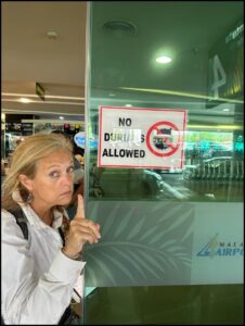 Quantz points to "No Durian" sign on store window.