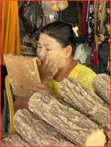 Woman using makeup from Thanaka tree in Burma.