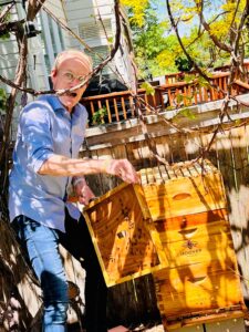 Karl Bruns-Kyler of The Big 65 holding Hoover bee hives in Colorado.