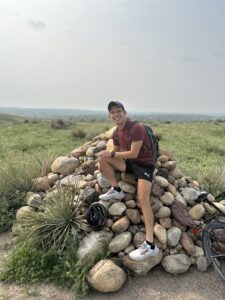 Santi sitting on a pile of rocks in Colorado.