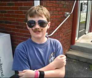 Nicholas as a young kid wearing a fake moustache.