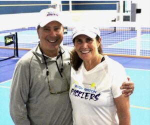 David and Pam Lippy on the pickleball court smiling.