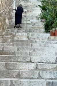 Woman walking some very steep stairs.