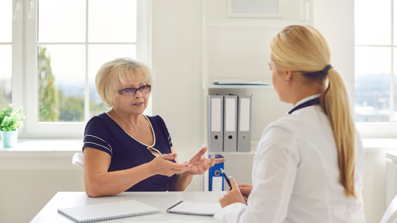 An elderly woman talking to a doctor in the hospital.