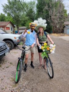 KC and Suz in costumes on their bicycles.