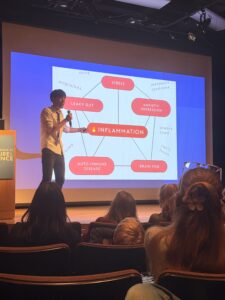 A man giving a talk in front of a screen about microbiome.