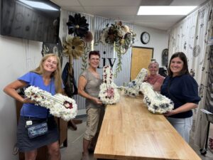 Quanzt along with several other women holding the flower arrangements they created.