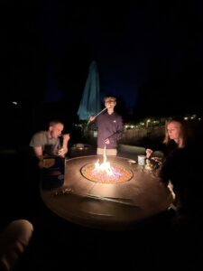 A group of people enjoying marshmallows over a fire.