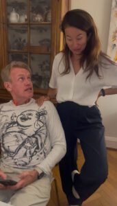 A young woman puts her hand on the shoulder of Karl.