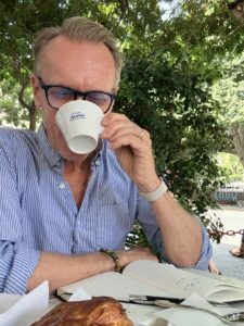 Karl the Medicare broker sipping from a small white cup.