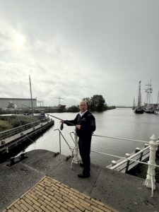 A man holding a rod connected to a rope with a shoe at the end.