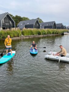 Three people on watercrafts on the water.