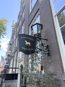 A sign with the words Singelkerk hanging from a brick building.