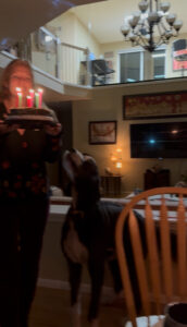 Quantz with a birthday cake with lit candles for Karl's birthday.