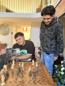 Two young men in front of a chess board.