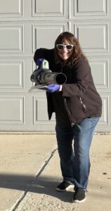 Sally holding a leaf blower.