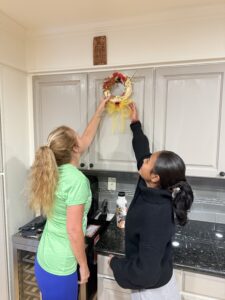 Quantz and Miti putting a wreath on the wall.