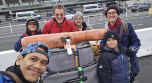 Luke and Carmen pick up their family at the airport.