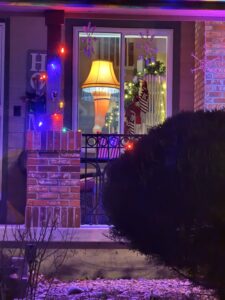 A lamp sitting on a table as seen through outside the window.