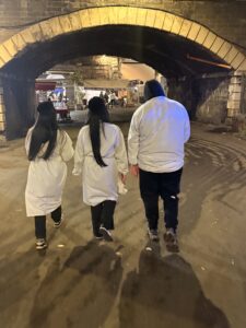 Three people in white walking. 