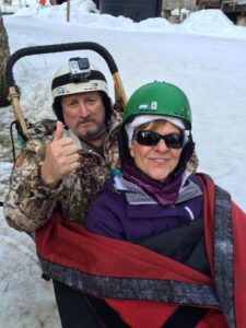 Shelly and Dave in a sled surrounded by snow.