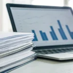 Laptop displaying charts and paperwork for comparing Wisconsin Medigap plans.