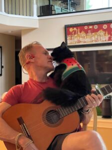 Karl playing his guitar for a cat.