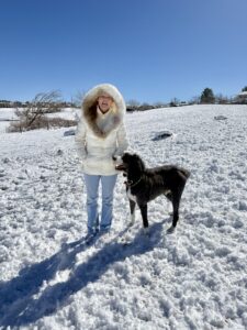 Quantz standing in the snow next to Plato, the big black and white dog.