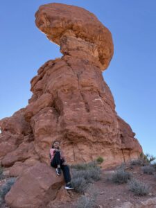 Miti sitting in front of a red rock formation.