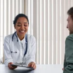 Healthcare professional reviewing Medicare and employer insurance documents with a patient