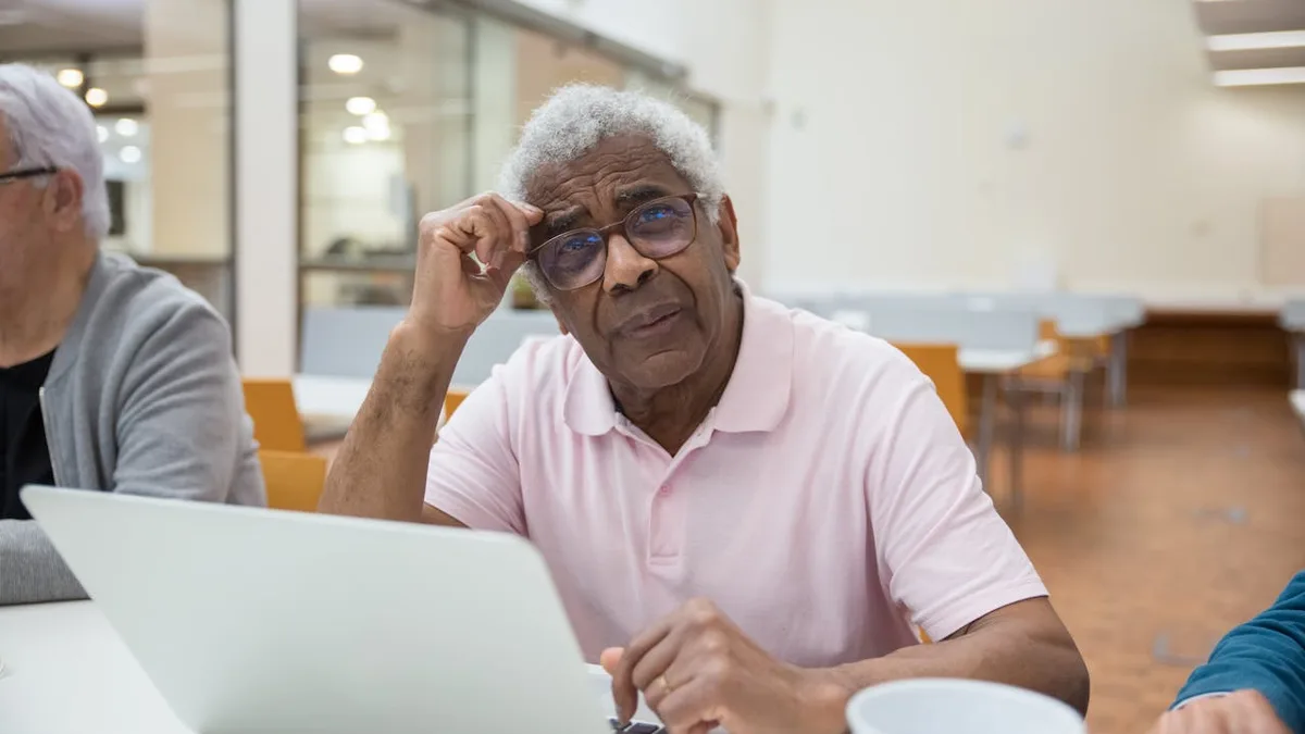 Senior reviewing Medicare primary and secondary payer rules on a laptop