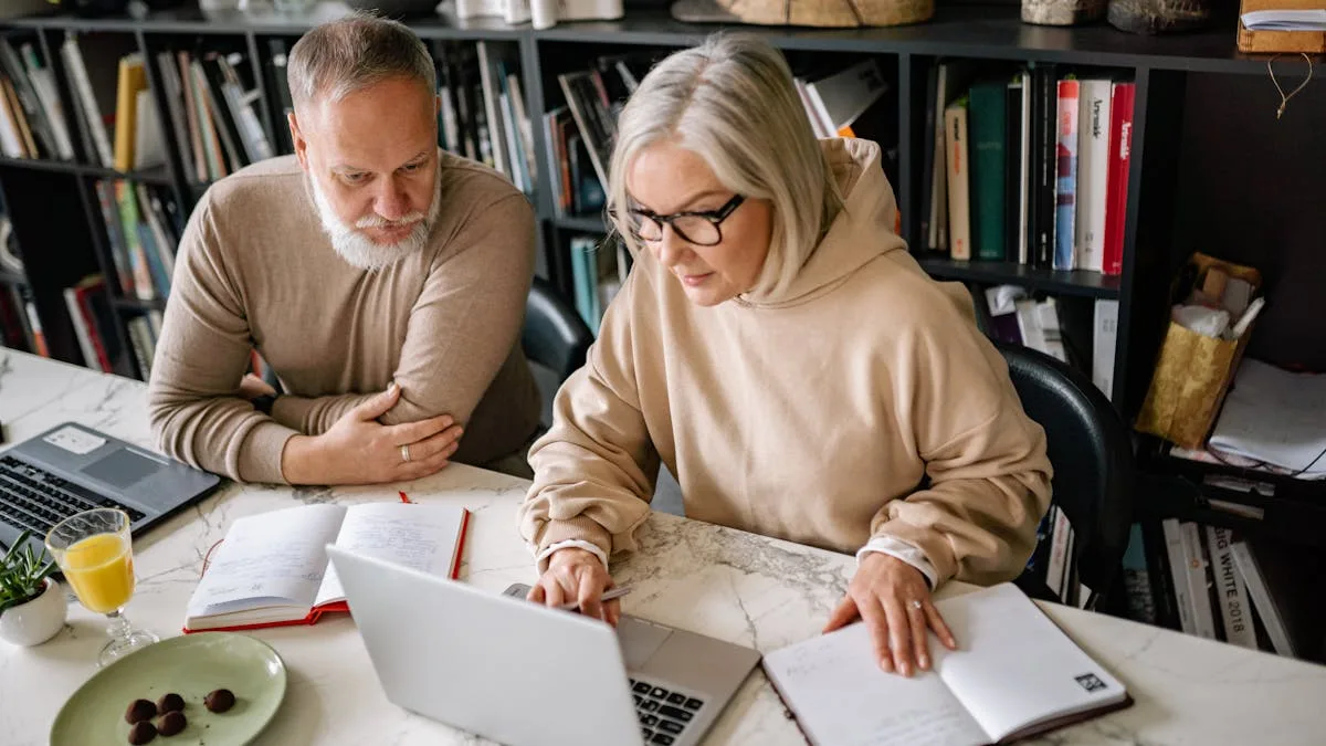 Elderly couple reviewing Medicare plan comparison documents together on laptops at home
