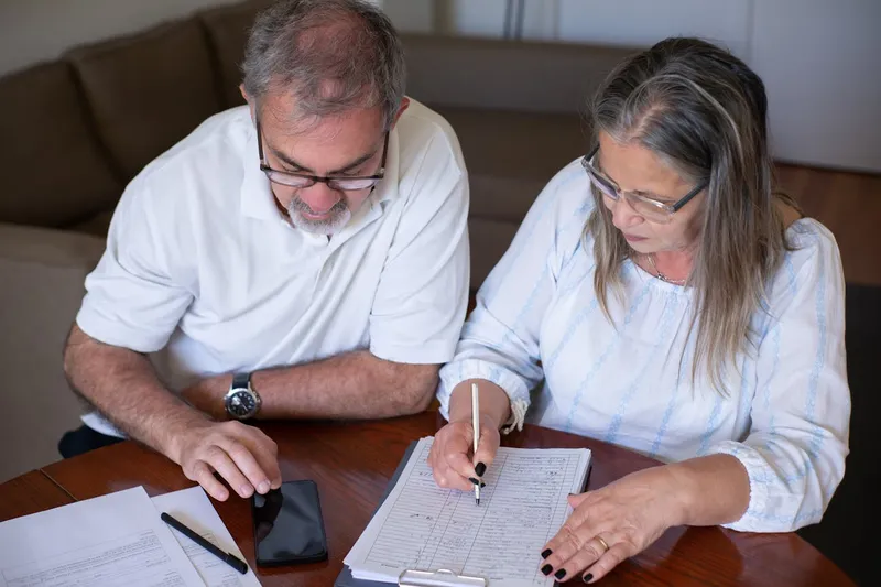 Senior couple reviewing Medicare plan options and enrollment documents together at home