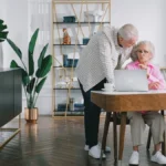 Senior couple reviewing Medicare enrollment paperwork at kitchen table