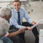 Senior couple consulting with a Medicare insurance agent in a professional office setting