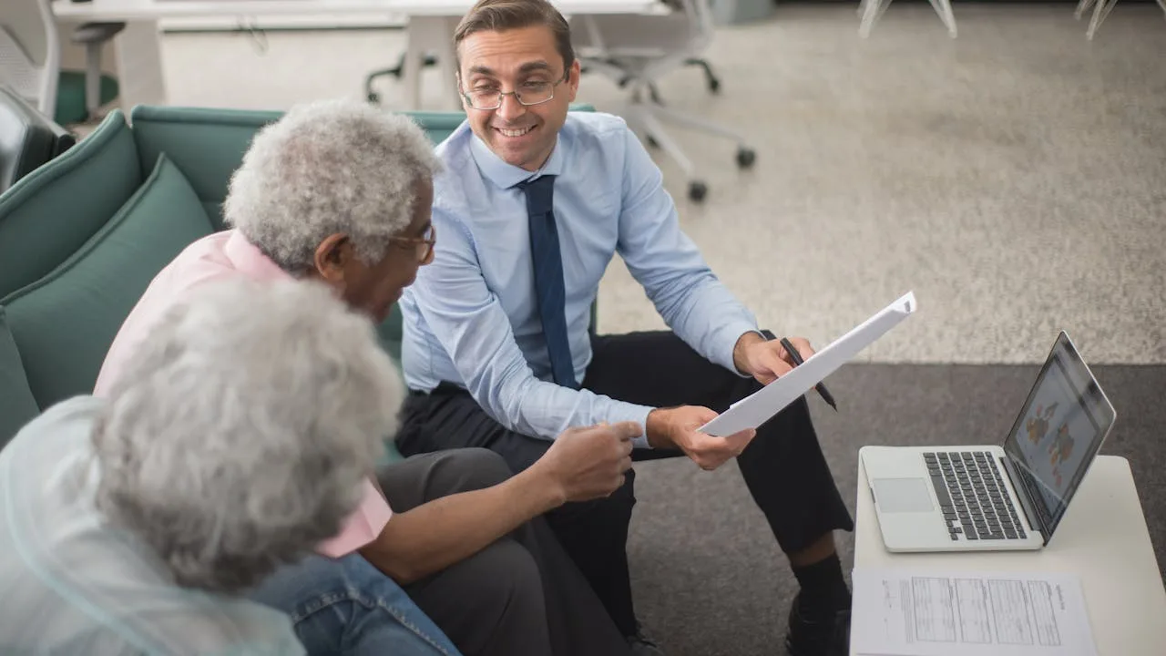 Senior couple consulting with a Medicare insurance agent in a professional office setting