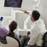 Senior at dentist office reviewing dental insurance options with Medicare cards and treatment cost estimates