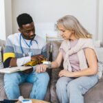 Healthcare professional checking blood pressure of elderly woman during a Medicare home health care visit