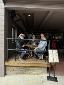 Three men having coffee together at a table.