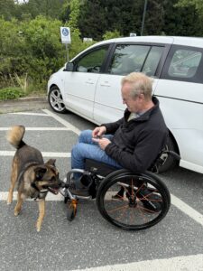 Karl's brother Rob with his dog next to a white car.