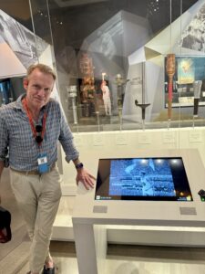 Karl standing next to a computer screen with a photo.