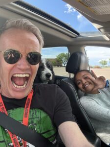 Karl and Miti in the front seat of the car with Plato in the back seat.