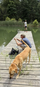 Two people on a dock fishing.