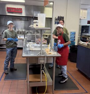 Three young people working in the kitchen.