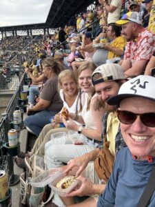 Karl and his family sitting in the stands of a baseball game.