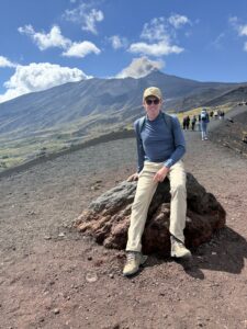 Karl sitting on a rock in front of an active volcano.