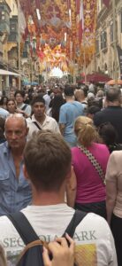 Throngs of people packed together walking down a pathway.