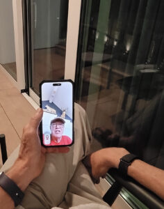 Karl holding an iPhone and facetiming with his brothers.