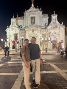 Karl and Nicholas standing next to each other in front of a historic structure.