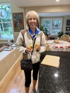Carol holding two containers of honey.